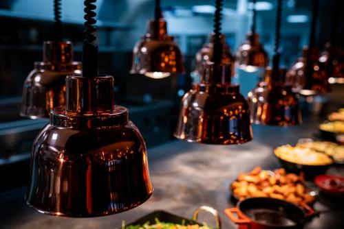 a group of lights hanging over a table with food at Stord Hotel in Stord