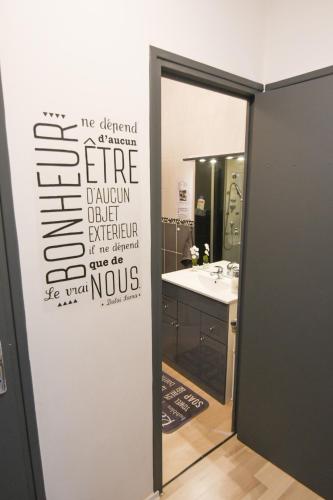 a bathroom with a sign on the wall of a bathroom at Appartement "le Terminus " Gare-Cosy-Wifi 6 Personnes in Saint-Quentin
