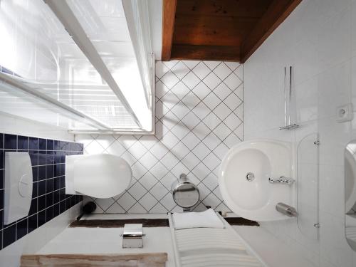 a white bathroom with a toilet and a sink at Penzion Kamenne Slunce in Telč