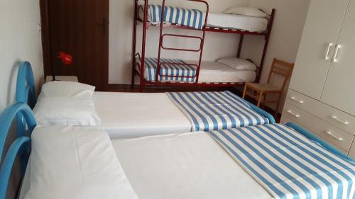 リド・ディ・イエゾロにあるRESIDENCE GALLO - WALTERIGATO Apartments PER SOLO FAMIGLIEの二段ベッド3組が備わるドミトリールームのベッド2台分です。
