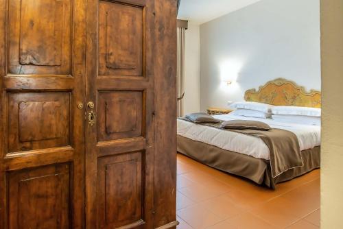 a bedroom with a bed and a large wooden door at Hotel Machiavelli Palace in Florence