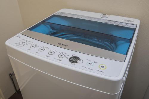 a washing machine with a screen on top of it at Shiki Homes KURIKO in Osaka