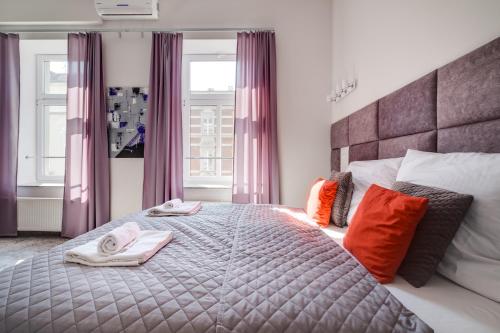 a bedroom with a large bed with towels on it at SAVOY Mariacka Apartments in Katowice