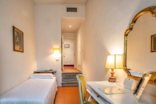 a room with a bed and a sink and a mirror at Hotel Machiavelli Palace in Florence