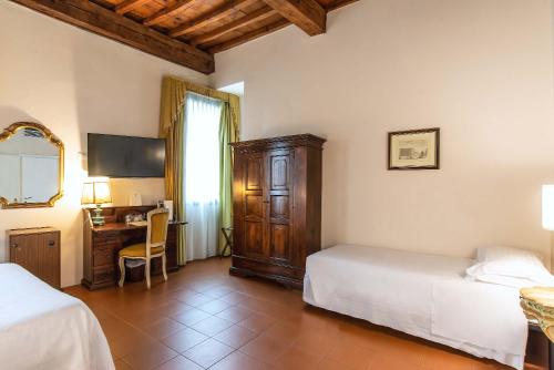 a bedroom with two beds and a desk with a computer at Hotel Machiavelli Palace in Florence