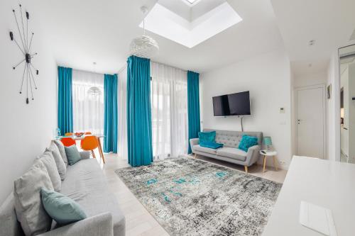 Apartamenty Sun & Snow Dune B في ميلنو: غرفة معيشة مع أريكة وتلفزيون