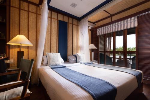 a bedroom with a large bed and a window at Yathra Houseboat in Bentota
