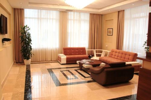 a living room with two couches and a table at Gabala Tufandag City Hotel in Gabala