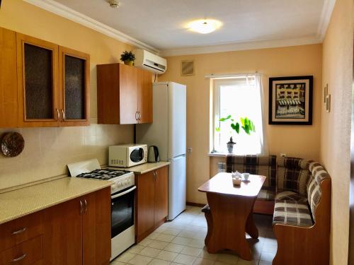 a small kitchen with a table and a refrigerator at Teremok Guest House in Sochi