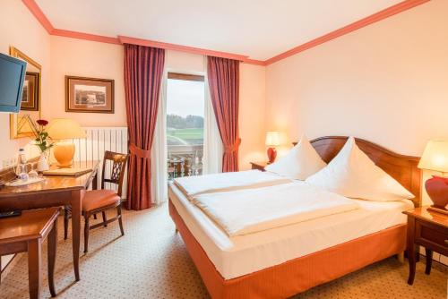 una camera d'albergo con letto e scrivania di Hotel-Gasthof Huber a Ebersberg