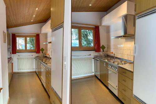 a large kitchen with white walls and wooden ceilings at La Civetta (714 La) in Valbella