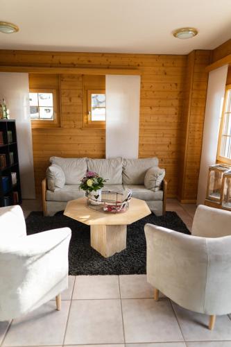 a living room with a couch and a table at Hotel Bellwald in Bellwald