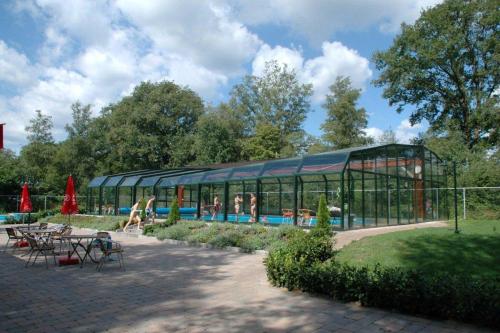 un bâtiment en verre avec des personnes dans une piscine dans l'établissement Familiepark de Vechtvallei, à Diffelen