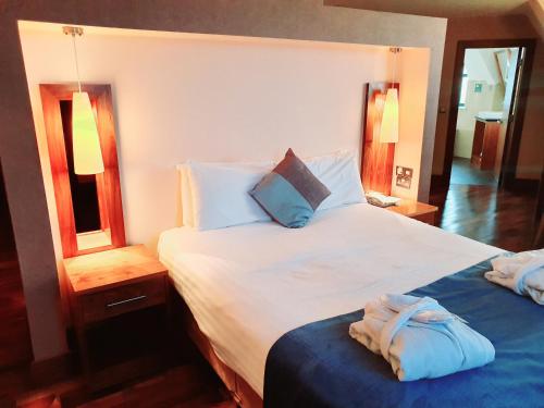a bedroom with a large bed with two towels on it at Westgrove Hotel in Clane
