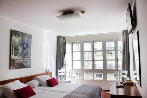 sypialnia z łóżkiem i dużym oknem w obiekcie Hotel Hórreo by Bossh! Hotels w Santiago de Compostela