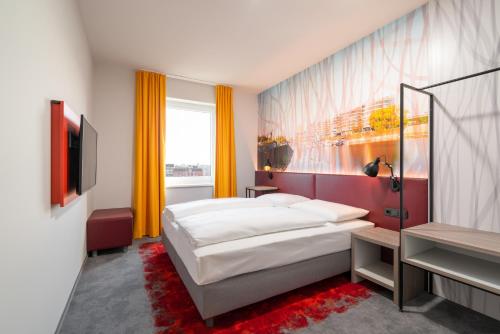 デュースブルクにあるCampanile Duisburg Cityのベッドとテレビがあるホテルの部屋
