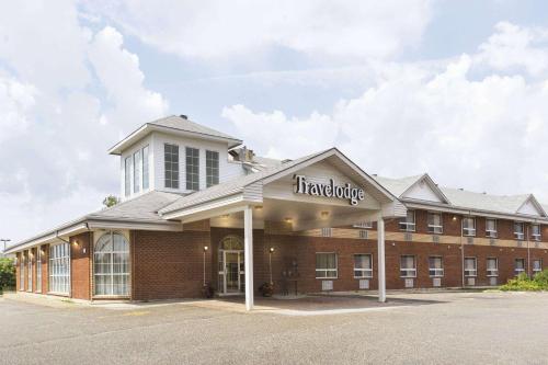 ティミンズにあるTravelodge by Wyndham Timminsの薬局看板が貼られた大きなレンガ造りの建物