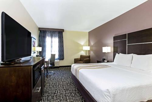 a hotel room with a bed and a flat screen tv at La Quinta by Wyndham Denver Gateway Park in Denver