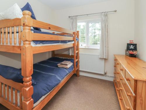 a bedroom with a bunk bed and a desk at 2 Organsdale Cottages in Kelsall Hill