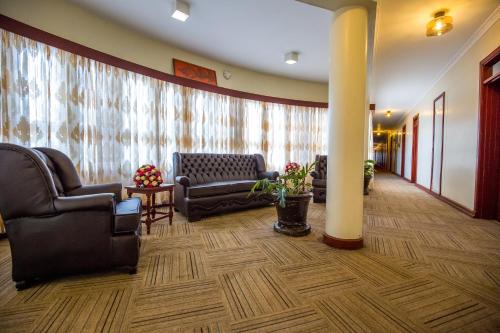 a waiting room with couches and chairs in a building at Sirikwa Hotel in Eldoret