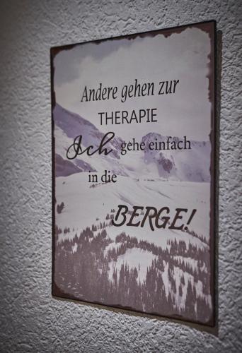 a sign hanging on a wall with a mountain at Appartement zum Turm Top 4 in Saalbach Hinterglemm