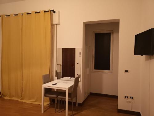 Zimmer mit einem Tisch, Stühlen und einem Fenster in der Unterkunft New Life in Mestre