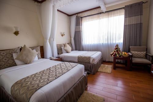 una habitación de hotel con 2 camas y un árbol de Navidad en Sirikwa Hotel en Eldoret