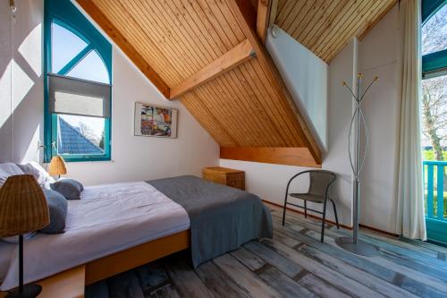 a bedroom with a bed and a large window at Fréjus 116 - Kustpark Village Scaldia in Hoofdplaat