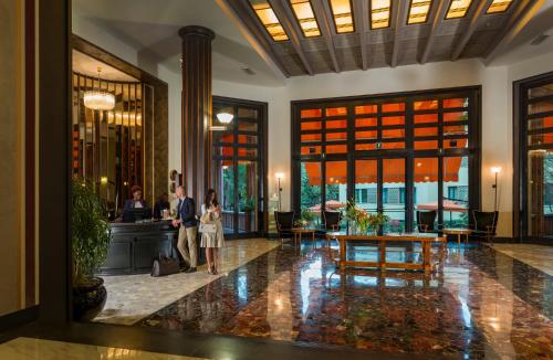 a man and a woman standing in a lobby at Grand Hotel Castrocaro Longlife Formula in Castrocaro Terme
