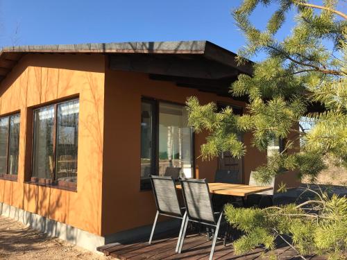 a house with a table and chairs on a deck at SKY Ranch in Izborsk