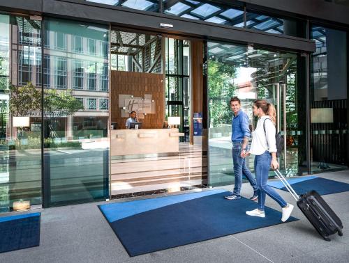 a man and woman walking into a building with a suitcase at Holiday Inn Express Singapore Clarke Quay by IHG in Singapore