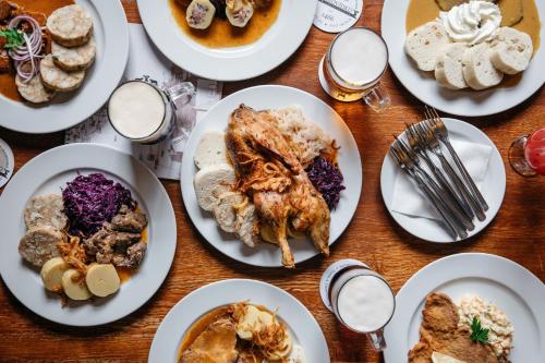 a wooden table with plates of food on it at U Medvidku-Brewery Hotel in Prague