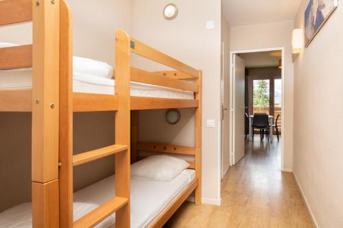 a dorm room with bunk beds and a hallway at SOWELL RESIDENCES Pra Loup in Pra-Loup