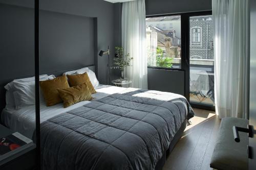 een slaapkamer met een groot bed en een groot raam bij Nôma Living Pop Saldanha in Lissabon