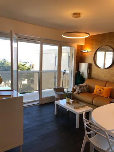 ein Wohnzimmer mit einem Sofa und einem Tisch in der Unterkunft Le Cézembre, au pied de la plage in Saint-Malo