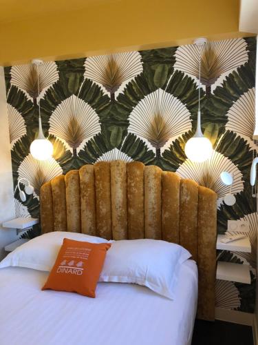 a bed in a room with a wall with a headboard at Le Cézembre, au pied de la plage in Saint Malo