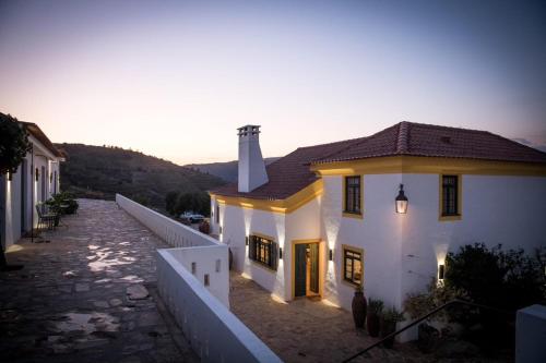 Una casa blanca con luces en el costado. en Quinta da Côrte, en Valença do Douro