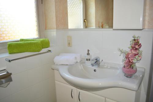 une salle de bain avec un lavabo et un vase de fleurs dans l'établissement Ferienwohnung Gassoid, à Fieberbrunn