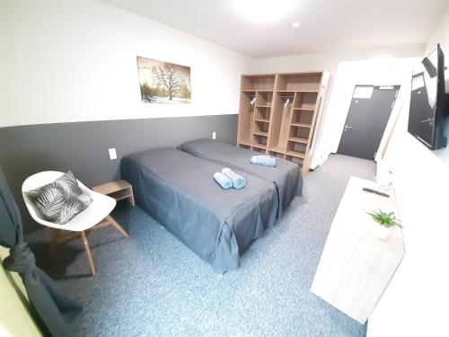 niewielka sypialnia z łóżkiem i krzesłem w obiekcie Office Base Bad Vöslau MOTEL w mieście Bad Vöslau