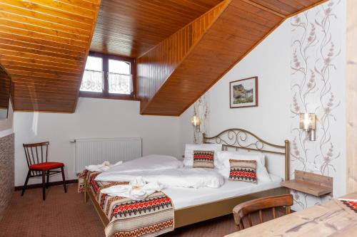 een slaapkamer met 2 bedden en een houten plafond bij Goralturist in Ždiar
