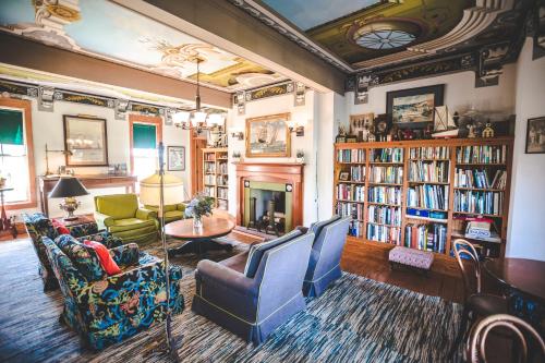 a living room with a fireplace and bookshelves at Roanoke Island Inn in Manteo
