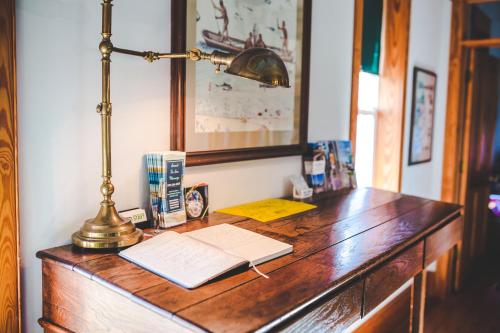 a desk with a lamp and a book on it at Roanoke Island Inn in Manteo