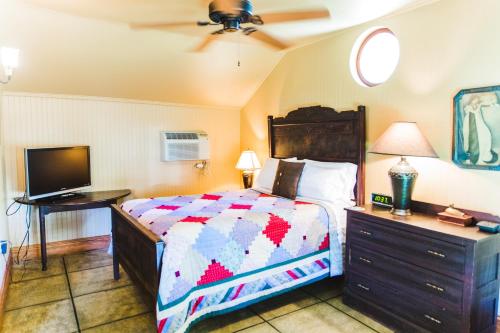 a bedroom with a bed and a flat screen tv at Roanoke Island Inn in Manteo