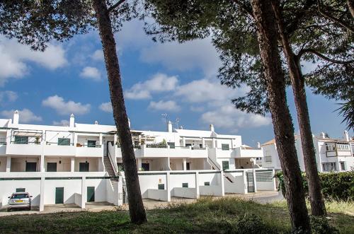 a white building with trees in front of it at Aptº ATALAYA , cerca de la Playa in Conil de la Frontera