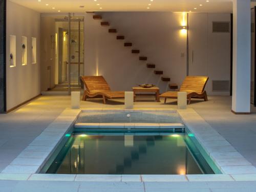 a swimming pool with two chairs and a staircase at Hotel Alto Traful in Villa Traful
