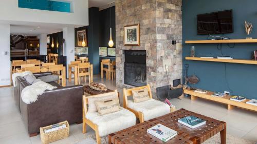a living room with a couch and a fireplace at Hotel Alto Traful in Villa Traful