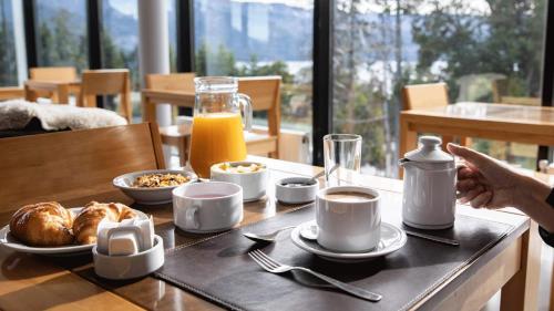 a table with a breakfast of coffee and croissants at Hotel Alto Traful in Villa Traful