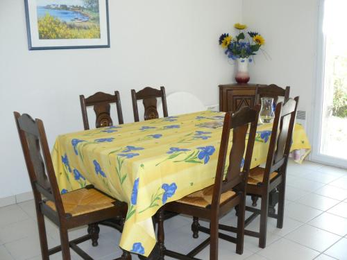 カルナックにあるParc des druides, maison à Carnacのダイニングルームテーブル(黄色と青のテーブルクロス付)