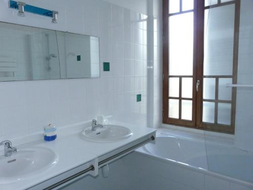ein Badezimmer mit einem Waschbecken, einer Badewanne und einem Spiegel in der Unterkunft Ker Corentine, maison de charme à Benodet, jardin in Bénodet