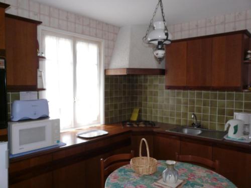 PouldreuzicにあるLaraon, maison à Pouldreuzicのキッチン(テーブル、電子レンジ付)、窓が備わります。